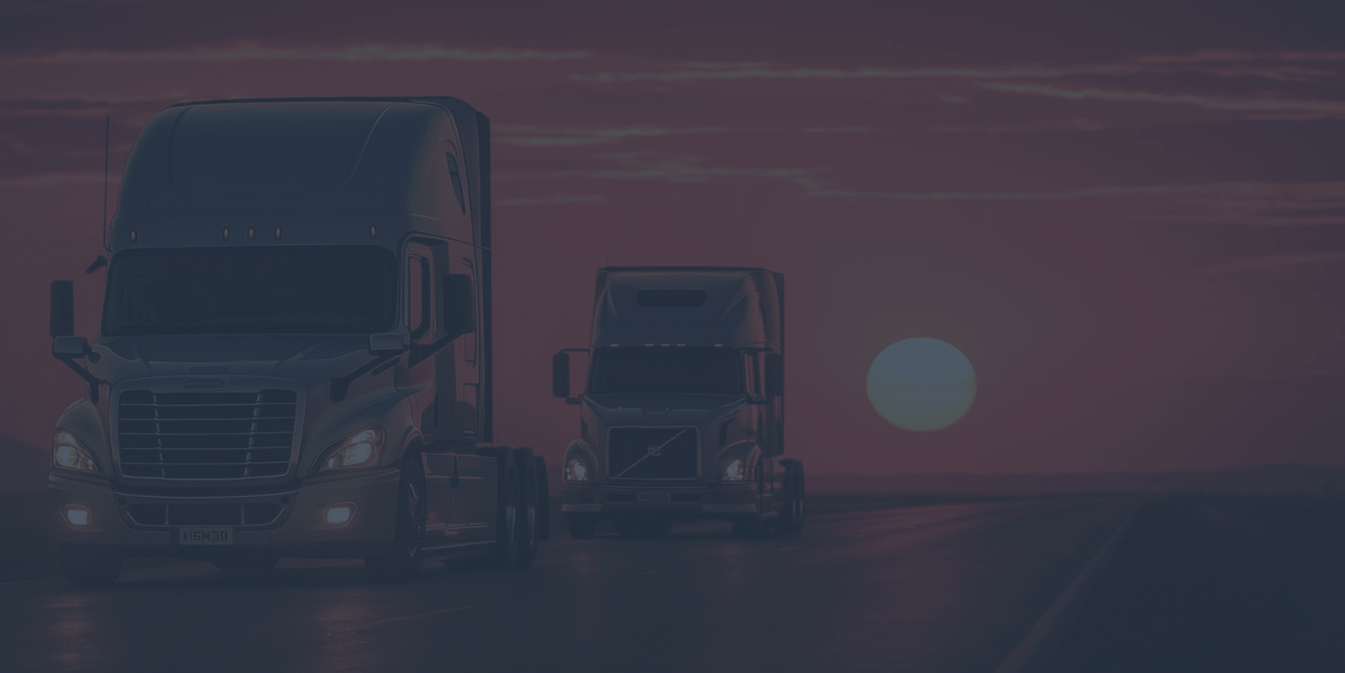 Two semi trucks driving on a highway at sunset