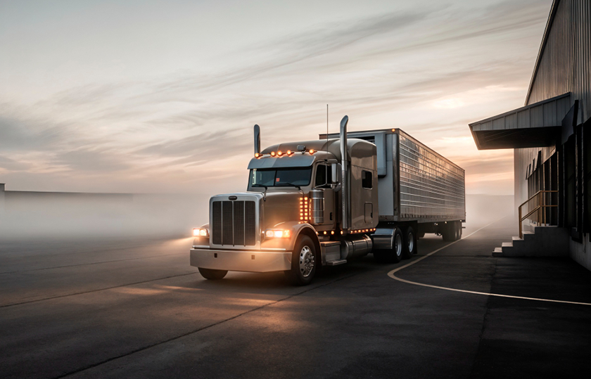 Freight truck parked at a warehouse loading dock, representing professional long-haul trucking operations